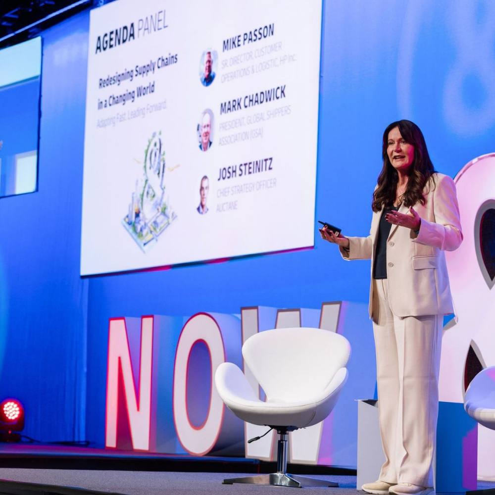A speaker on the main stage at the DHL Now & Next convention.
